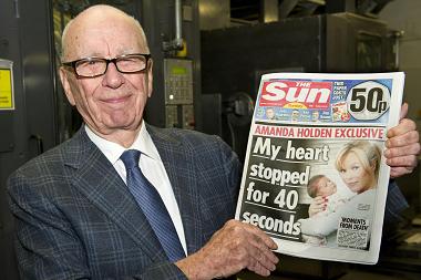 Rupert Murdoch holding a copy of the Sun on Sunday newspaper